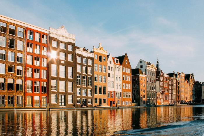 Casas típicas de Ámsterdam junto a un canal, iluminadas por el sol