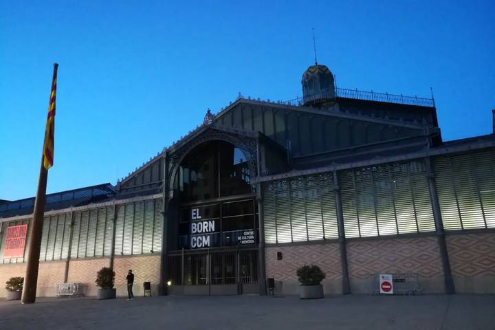 La fachada de hierro y cristal del antiguo mercado del Born, iluminada al anochecer