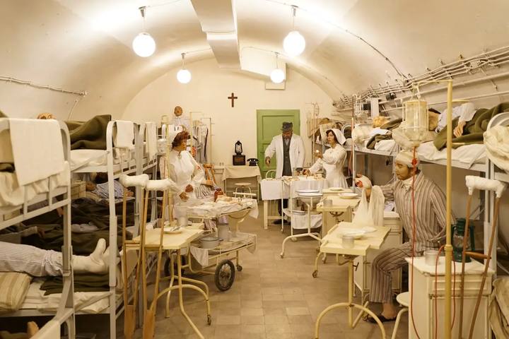 Sala abovedada del Hospital en la Roca con literas, camillas y maniquíes de médicos y enfermeras