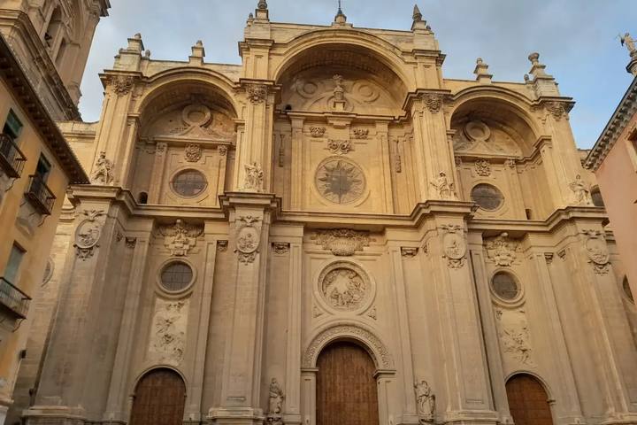 Fachada principal de la Catedral de Granada, de piedra dorada, con sus tres grandes arcos