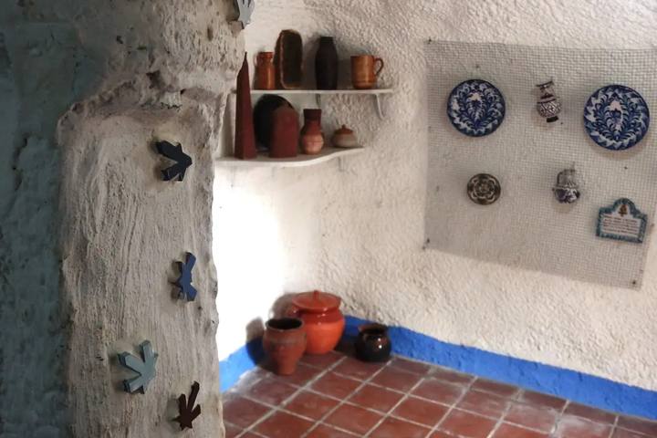 Interior encalado de una casa-cueva del Museo Cuevas del Sacromonte, con cerámica granadina