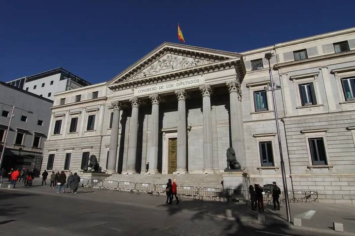 Fachada del Congreso de los Diputados, con sus columnas, el frontón y un león de bronce a cada lado de la escalinata