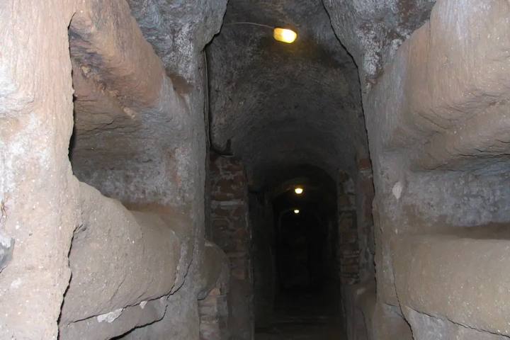Galería subterránea de las catacumbas de San Calixto excavada en la toba, con nichos funerarios a ambos lados