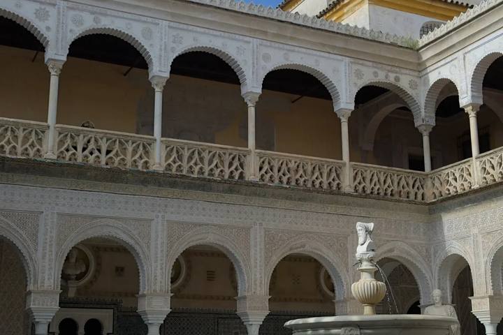 Patio principal de la Casa de Pilatos con arcos de yesería blanca y su fuente central