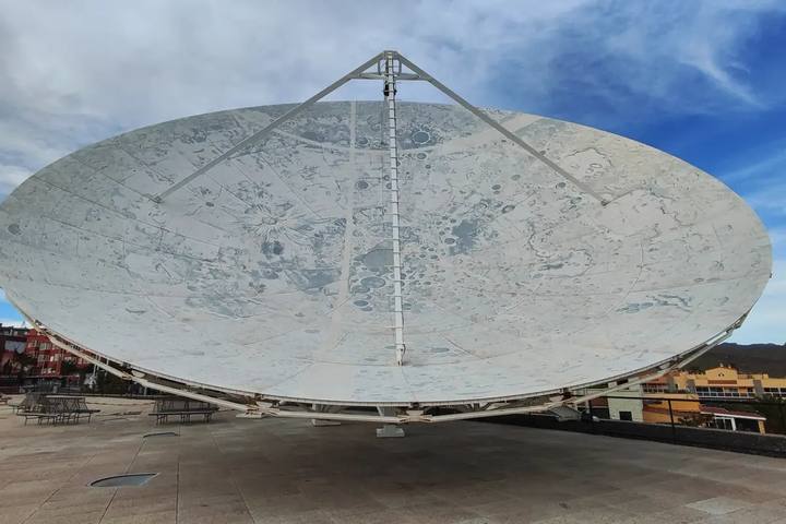 Gran antena parabólica blanca con un mapa de la Luna pintado, en la explanada exterior del Museo de la Ciencia y el Cosmos
