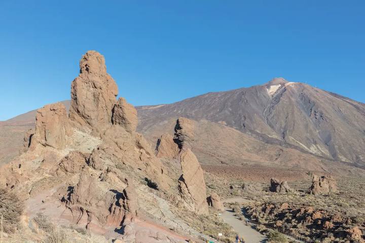 Los Roques de García, grandes formaciones de roca volcánica, con el pico del Teide al fondo bajo un cielo azul