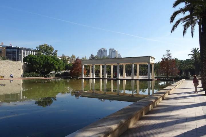 Estanque con columnata y palmeras en el Jardín del Turia de Valencia, antiguo cauce del río, en un día soleado