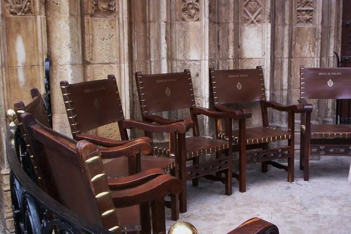 Sillones de cuero del Tribunal de las Aguas con los nombres de las acequias, ante la puerta de los Apóstoles de la Catedral