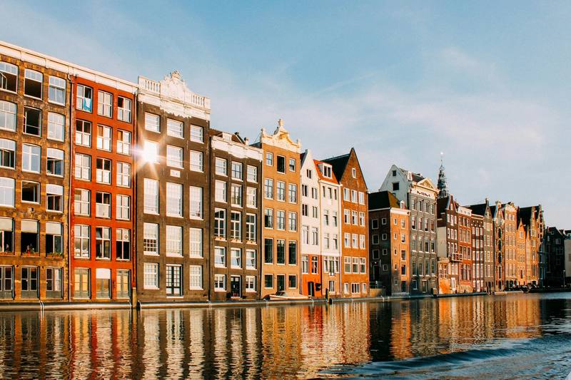 Casas típicas de Ámsterdam junto a un canal, iluminadas por el sol