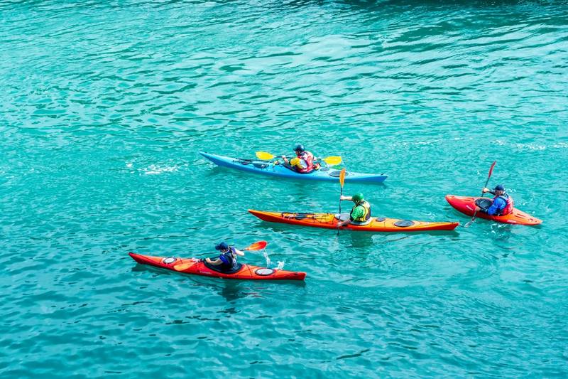 Grupo haciendo kayak en aguas turquesas