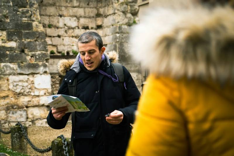 Guía explicando un recorrido con un mapa a un grupo pequeño